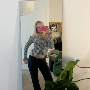 Svartvit rutig offshoulder topp -  svartvit rutig offshoulder topp med långa ärmar och volangdetaljer. 