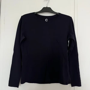 Navy långärmad tröja från Cubus  - Säljer en stilren navy långärmad tröja från Cubus, tillverkad i mjuk ekologisk bomull. Perfekt för en minimalistisk look. Tröjan har en rund halsringning och en bekväm passform.