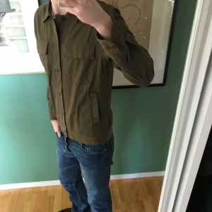 Olivgrön overshirt från GANT  - Säljer en riktigt shysst overshirt från GANT i väldigt bra skick. Skönt kvalitets material som är perfekt nu inför våren. Storlek M. För referens så är jag 190cm och sitter lite kort i midjan. Passar 170cm och uppåt.  (Färgen på sista bilden stämmer inte överrens med verklighet).