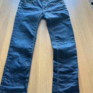 Mörkblå jeans från Replay - Snygga mörkblå jeans från Replay med klassisk femficksdesign och knappgylf. Perfekta för en stilren look. Märkesdetaljer syns på fickorna och baksidan. Priset kan diskuteras.