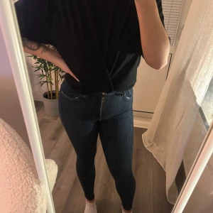 Levi’s Mile High Super Skinny - Snygga mörkblå skinny jeans med hög midja. Perfekta för en stilren look. De har klassiska fem fickor och en knappgylf. Passar utmärkt till både vardag och fest.