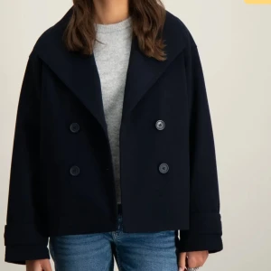 Marinblå kappa med knappar - Snygg mörkblå kappa med dubbelknäppning och bred krage. Jackan har en stilren design med långa ärmar och är perfekt för kyligare dagar. Passar bra till både jeans och mer uppklädda outfits. Kappan är använd men har inga speciella deffekter förutom små nopprar 🌸strl 160 från barnstrl men passa en s! 