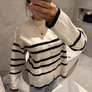 Randig tröja från Vero Moda - Säljer en snygg randig tröja från Vero Moda i beige och svart. Tröjan har långa ärmar och en bekväm passform med ribbad krage och ärmslut. Perfekt för en stilren look. Jätteskön och mysig tröja!!! 