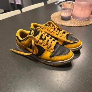 Nike Dunk ”goldenrod” - Snygga ”goldenrod” Nike Dunk sneakers. Skorna har klassisk snörning och en vit sula som kontrasterar snyggt mot det färgglada ovandelen. Köpta när dom va nysläppta med använda knappt dom.