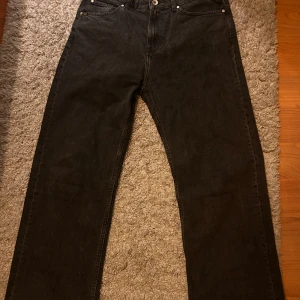 Svarta jeans från Tiger of Sweden - Snygga svarta jeans från Tiger of Sweden. Klassisk design med fem fickor. Perfekta för en stilren look. Straight/loose fit. W28 L32. Aningen kortare då de är klippta i botten. Annars väldigt bra skick.