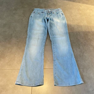 Lågmidjade bootcut jeans  - (2) Ljusblåa lågmidjade bootcut jeans med stretch i, midjemått rakt över: 35cm, innerbenslängd: 76cm. 🩷