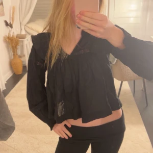 Svart blus med spetsdetaljer - Säljer en svart blus med spetsdetaljer och volang vid axlarna från Gina young💕 storlek 148/152 men passar xxs/xs men blir lite kortare