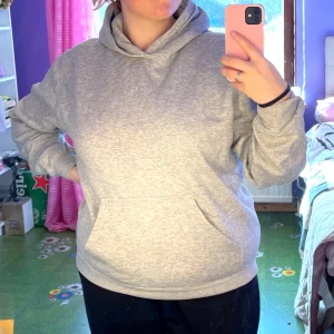 Grå hoodie från Southwest - Säljer en grå hoodie från Southwest med trycket 'Dans för Hälsa' på baksidan. Tröjan har en klassisk design med en stor ficka framtill och en bekväm huva. Perfekt för en avslappnad stil.