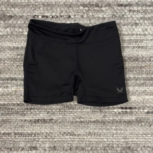 Svarta träningsshorts från SOC - Säljer ett par svarta träningsshorts från SOC. De är tillverkade i ett tekniskt material som håller dig torr och bekväm under träning. Perfekta för aktiva dagar!🌺