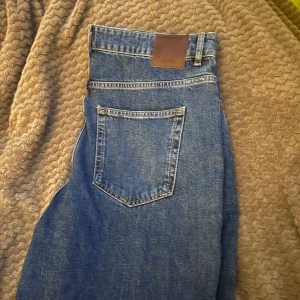 Blå jeans med hög midja - Snygga blå jeans med hög midja och klassisk femficksdesign. Perfekta för en avslappnad stil. De har en rak passform och är tillverkade i slitstarkt denim. Aldrig använt 