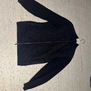 Svart jacka från Massimo Dutti - Snygg mörkblå jacka/cardigan från Massimo Dutti med quiltad framsida och dragkedja. Jackan har långa ärmar och en stilren design som passar perfekt för höst och vår. Storlek L passar Medium. 