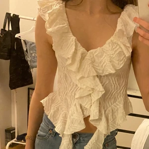 Vit volangtopp - Säljer en söt vit volangtopp från Zara med volanger framtill och vid ärmslut. Skriv gärna vid frågor💕