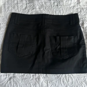 Svart jeans mini kjol  - Säljer denna unika vintage mini kjol som inte går att få tag på längre🙌🏼 härligt jeans material med underbara detaljer!! perfekt ni till vår och sommar ☀️