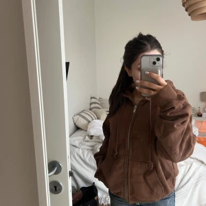 Brun hoodie med dragkedja - Säljer en mysig brun hoodie med dragkedja och huva från brandy Melville. Den har en avslappnad passform och är perfekt för kyliga dagar. Fickor framtill för extra bekvämlighet. Perfekt för en casual look!