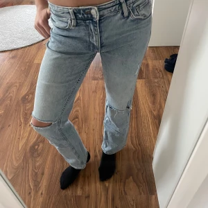 straight low waist jeans H&M - Säljer ett par ljusa jeans från H&M med en straight passform och låg midja. Jeansen har slitna detaljer vid knäna och justerbarmidja. Bra skick även fast använt mycket!