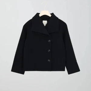 Mörkblå kappa med knappar - Snygg mörkblå kappa med stora knappar framtill. Den har en klassisk krage och långa ärmar, perfekt för en stilren look. Passar bra till både jeans och mer uppklädda outfits.