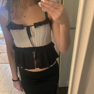 Beige och svart topp från Zara - Snygg topp från Zara i beige och svart med smala axelband och spetsdetaljer. Toppen har en volangkant och knytning framtill! 