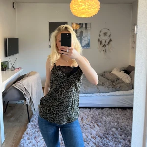 Leopard linne  - Super fint leopard linne med spetsdetalj upptill. Axelbanden är justerbara. Linnet är i fint skick och har inga defekter. 