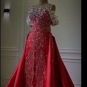 Röd långklänning med paljetter - Fantastisk röd långklänning med glittrande paljettdetaljer och offshoulder-design. Perfekt för en glamorös kväll med en elegant och iögonfallande look.