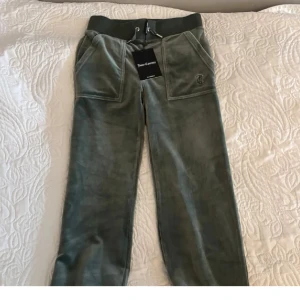 Gröna mjukisbyxor från Juicy Couture - Snygga gröna mjukisbyxor från Juicy Couture med elastisk midja och snörning. Byxorna är i storlek XXS och passar folk allt mellan 155 till 165+. Dem är alltså väldigt bra då dem anpassar sig mycket efter användaren. Köpta för 1400kr och säljs nu för