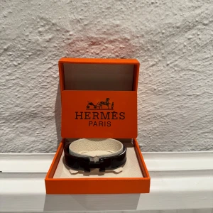Svart H armband  - Elegant svart H armband en stilren design. Armbandet kommer i en klassisk orange H förpackning med autenticitetskort. Perfekt för att ge en lyxig touch till din stil. Ny pris ca 5200, var nu inte rädd att höra av dig vid några frågor eller funderingar!