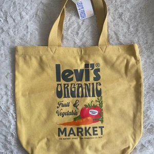 Gul shoppingväska från Levi's - En helt ny oanvänd Tote bag från Levi’s som är slutsåld. Rymmer mycket. Ny pris ca 600kr