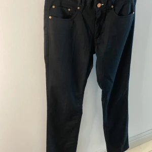 Svarta jeans från Acne - Svarta jeans från Acne. De har en rak passform och är tillverkade av en blandning av bomull och polyester. Jeansen har fem fickor och knappar med Acne-logga. Klassiska!