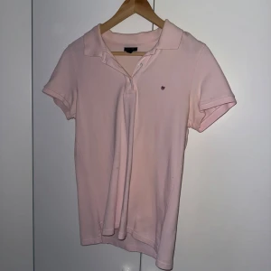 Ljusrosa pikétröja från Gant - Säljer en stilren ljusrosa pikétröja från Gant. Tröjan har korta ärmar och är slimfit