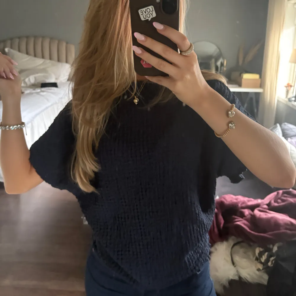 Säljer en mörkblå topp med korta ärmar. Perfekt för en avslappnad look. Toppen har en enkel design som gör den lätt att matcha med olika outfits.. Yläosat.