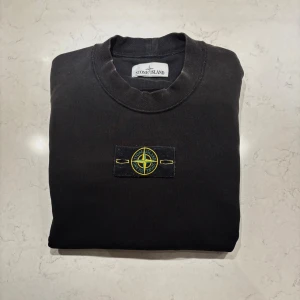 Svart Stone Island Sweatshirt  - En riktigt fin sweatshirt från Stone Island i mycket fint skick! Denna är i storlek M men sitter som en S. Nypris på denna ligger runt 3000kr, säljs för endast 879kr! 