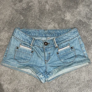 Ljusblå jeansshorts från ONLY - Snygga ljusblå jeansshorts från ONLY med klassisk femficksdesign och knappgylf. Perfekta för varma sommardagar. De har en lågmidjad passform och är tillverkade i slitstarkt denim.