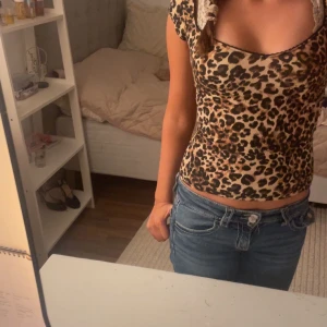 Leopardmönstrad topp - Säljer en snygg leopardmönstrad topp i tight passform. Perfekt för en utekväll eller fest! Toppen har korta ärmar och en rund halsringning. Den är gjord i ett mjukt och stretchigt material som sitter bekvämt hela dagen.