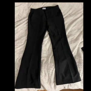 Svarta byxor från Gina Tricot - Snygga svarta byxor från Gina Tricot i storlek 38. Säljer då mina byxor från Gina Tricot då den inte kommer till användning,Dom är lågmidjade bootcut och är i mycket bra skick och passar till alla tillfällen💓