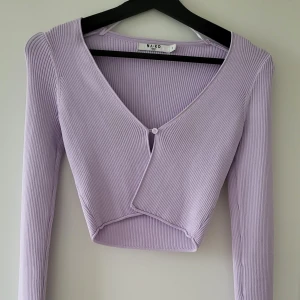 Ljuslila ribbad kofta från NA-KD - Säljer en superfin ljuslila ribbad kofta från NA-KD i storlek S. Den är croppad med en snygg v-ringning och en knapp framtill. Del av matchade set.  Storlek: S  Skickas inslagen i silkespapper i vattentätt paket.   Skicka pm för fler bilder. 