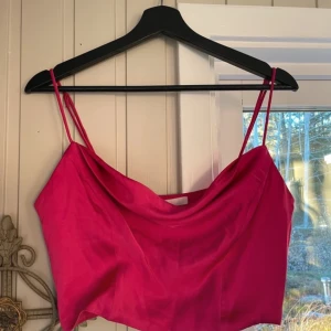 Rosa linnetopp från H&M - Säljer en snygg rosa linnetopp från H&M i storlek M. Toppen har tunna axelband och en stilren design, perfekt för sommardagar eller festliga tillfällen. Materialet känns mjukt och bekvämt. 