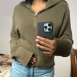 Half zip up dam - Säljer en supermysig olivgrön stickad half zip up . Perfekt för kyliga dagar med sin långa ärmar och ribbade detaljer. Den har en avslappnad passform och är idealisk för både höst och vinter. Passar perfekt till jeans för en casual look. Använts bara ett få tal gånger.