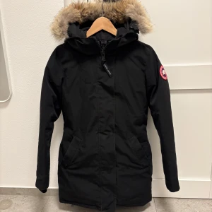 Canada Goose Jacka ”Victoria Parka” - Säljer en svart parkajacka från Canada Goose🌟 | Bra skick 8/10 | Storlek: S | Jackan har en varm pälsfodrad huva och dragkedja framtill. Perfekt för kalla vinterdagar❄️ | Klassisk design med logga på armen | Modell: Victoria Parka | Nypris: 13990 mitt pris: 5999kr | Hör av er vid funderingar | A&Wfashion