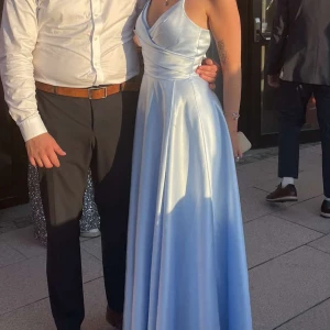 Ljusblå balklänning  - Storlek 36, är använd en gång och är i bra skick. Klänningen är i satäng och har slits vid benet och är  från JJ house. Nypris 1629kr