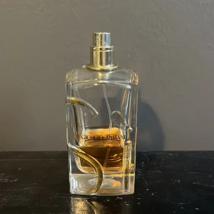 Parfym från Giorgio Armani - Säljer en elegant parfym från Giorgio Armani. Flaskan är genomskinlig med en gyllene detalj och har en stilren design. Perfekt för den som vill ha en lyxig doftupplevelse. Flaskan är delvis använd men fortfarande mycket kvar. Passar både till vardags och fest!