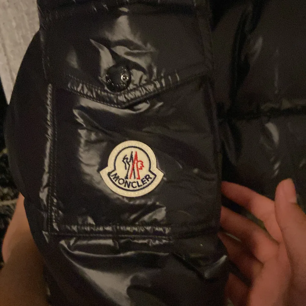 Säljer en snygg svart pufferjacka från Moncler i mycket bra skick. Jackan har en glansig finish och är perfekt för kalla dagar. Den har en dragkedja framtill och en huva för extra värme. Perfekt för vintern! 🖤. Jackor.