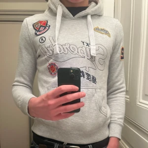Grå hoodie från Superdry - Hoodie från superdry i bra skick! Killen på bilden är ca 178cm, 66kg. Hör av dig vid frågor!