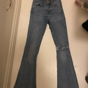 Bootcut jeans med hål i knät - Midwaisted bootcut jeans från gina tricot 💙 Säljer pga att de är för små för mig. Finns ett par små defekter som inte märks. Köpt för 500kr, väl använda därav priset. skriv gärna innan du köper ❤️