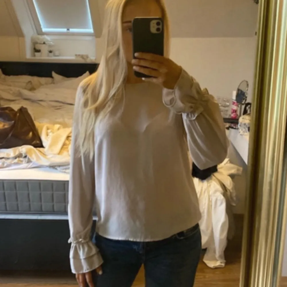 Säljer en superfin beige/ljus ros blus i mycket bra skick. Den har en lös passform och är perfekt för både höst och vår. Ärmarna har en söt volangdetalj vid muddarna. Perfekt att matcha med jeans för en avslappnad look!. Blusar.