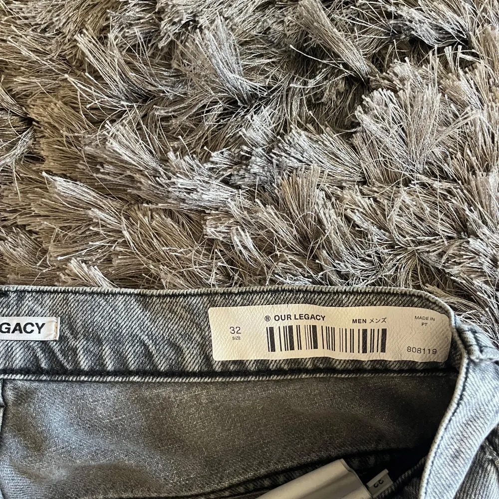 Säljer ett par grå jeans från Our Legacy i storlek 32. De har en cool patchwork-design med mörkare grå partier på knäna. Perfekta för en avslappnad stil och passar till både vardag och fest. Dragkedja och knapp framtill. Sköna och stilrena!. Farkut & Housut.
