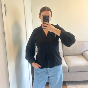 Fin enkel topp med knappar - Fin topp från boohoo, mycket bra skick. Figursydd i sidorna med lite större ärmar, knappt använd!