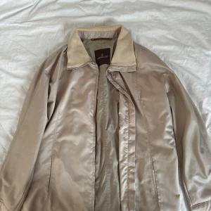 Beige jacka från Moncler - Säljer en snygg beige jacka från Moncler i mycket bra skick. Jackan är långärmad och gjord av polyester, vilket gör den perfekt för höst och vår. Den har en stilren design med dragkedja framtill. Passar både till vardags och lite finare tillfällen.