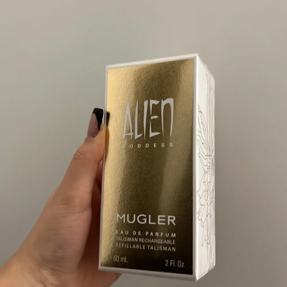 Säljer en lyxig Alien Goddess Eau de Parfum från Mugler. Flaskan är 60 ml och har en elegant guld- och vit design. Perfekt för den som vill ha en unik och förtrollande doft. Den är också påfyllningsbar, vilket är superpraktiskt!. Parfym.