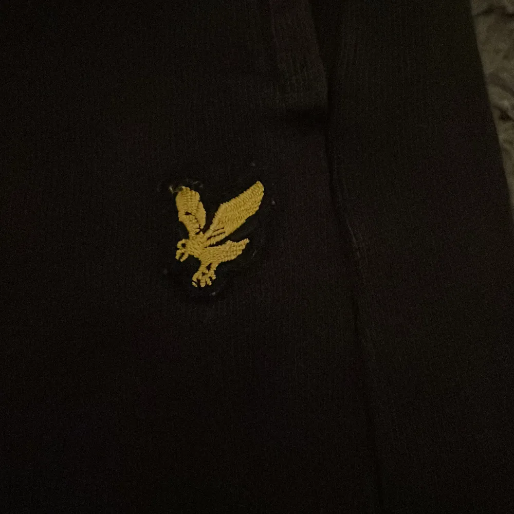 Säljer ett par svarta mjukisbyxor från Lyle & Scott i storlek 14/15 år. Byxorna har en broderad gul logga på sidan och är i mycket bra skick. Perfekta för en avslappnad stil eller mysiga dagar hemma. . Jeans & Byxor.