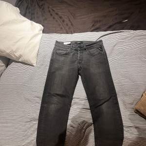 Säljer ett par snygga svarta jeans från Replay, modell Grover. De har en klassisk femficksdesign och är i mycket bra skick. Perfekta för både vardag och fest! Passformen är normal och de har en stilren look med knapp och dragkedja framtill. Vid mer frågor är de bara och skriva 