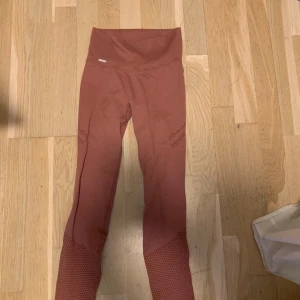 Rosa leggings från Aim'n - Säljer ett par snygga rosa leggings från Aim'n. De är högmidjade och har en ribbad detalj vid midjan. Perfekta för träning eller en avslappnad dag. Materialet är mjukt och stretchigt för bästa komfort.